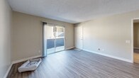 Located at 4555 Pine St in Riverside, CA, this 2-bedroom, 3-bathroom residence offers a well-designed single-floor layout with a cohesive, neutral color palette throughout. The open-concept living and dining area flows seamlessly into the kitchen, which features crisp white cabinetry, dark countertops, stainless steel appliances including a refrigerator, range, and microwave, and a peninsula breakfast bar with bar seating — ideal for casual dining or entertaining. Durable wood-style flooring runs through the main living areas, complemented by ceiling fans and textured ceilings that add character to the space. The living room opens to a private balcony through a sliding glass door, bringing in natural light and outdoor access. The two bedrooms offer plush carpeting, vertical blind-covered windows for natural light, and generous closet space — with five closets distributed throughout the unit. The primary bedroom provides a comfortable, well-proportioned retreat. Three full bathrooms include clean, all-white tub and shower surrounds. Additional highlights include a pantry, a utility room, and ample storage throughout, making this a highly functional and comfortable residence in Riverside.