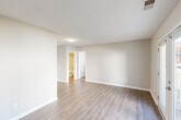 Located at 700 S Clinton St in Athens, Alabama, this one-bedroom, one-bathroom unit offers a practical and well-organized single-floor layout. The combined kitchen and living area is finished with light-toned luxury vinyl plank flooring that extends throughout the main living spaces, creating a clean, cohesive look. Neutral beige walls and textured ceilings add a subtle warmth to the open area.

The kitchen is efficiently designed, featuring white cabinetry, a granite-patterned countertop, a stainless steel sink, and black appliances including an electric range with overhead ventilation. The layout maximizes functionality within a compact footprint.

The bedroom is carpeted for comfort and is equipped with a ceiling fan with light fixture, providing both airflow and ambient lighting. A window allows natural light to fill the room. An adjacent closet offers dedicated storage with a full-width wire shelving system and washer/dryer hookups, adding everyday convenience.

The bathroom includes a full tub-shower combo with clean white surround, a toilet, and crown molding detail at the ceiling. Throughout the unit, white trim and panel doors maintain a consistent, tidy aesthetic. This unit presents a straightforward, move-in ready space suited for practical, comfortable living.