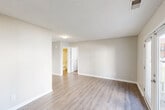 Located at 700 S Clinton St in Athens, Alabama, this one-bedroom, one-bathroom unit offers a practical and well-organized single-floor layout. The combined kitchen and living area is finished with light-toned luxury vinyl plank flooring that extends throughout the main living spaces, creating a clean, cohesive look. Neutral beige walls and textured ceilings add a subtle warmth to the open area.

The kitchen is efficiently designed, featuring white cabinetry, a granite-patterned countertop, a stainless steel sink, and black appliances including an electric range with overhead ventilation. The layout maximizes functionality within a compact footprint.

The bedroom is carpeted for comfort and is equipped with a ceiling fan with light fixture, providing both airflow and ambient lighting. A window allows natural light to fill the room. An adjacent closet offers dedicated storage with a full-width wire shelving system and washer/dryer hookups, adding everyday convenience.

The bathroom includes a full tub-shower combo with clean white surround, a toilet, and crown molding detail at the ceiling. Throughout the unit, white trim and panel doors maintain a consistent, tidy aesthetic. This unit presents a straightforward, move-in ready space suited for practical, comfortable living.