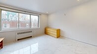 Situated at 80 Avenue des Pins Ouest in Montréal's dynamic Plateau-Mont-Royal neighbourhood, this single-floor unit offers a thoughtfully organized layout that makes excellent use of its compact footprint. The main living area is bright and open, featuring polished marble-effect tile flooring that reflects natural light streaming in through a large window with views of the surrounding urban streetscape. Clean white walls and recessed lighting contribute to an airy, modern ambiance throughout.

The kitchen is neatly defined within its own alcove, showcasing white shaker-style cabinetry, a classic white subway tile backsplash, a stainless steel refrigerator, and a single-basin sink — a functional and visually cohesive space. Dark marble-effect tile flooring in the kitchen area provides a stylish contrast to the lighter tones of the main room.

The bathroom is finished with grey square wall tiles accented by a black border detail, a full soaking tub with an overhead shower, a pedestal-style vanity with a dark wood cabinet, and a framed mirror — offering a clean, classic aesthetic. A dedicated closet provides practical storage. With its central Montréal location and well-appointed interiors, this unit presents a highly functional urban living space.