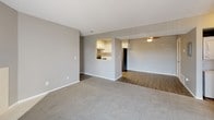 Located at 742 Western Dr in Colorado Springs, Colorado, this single-floor residence offers a well-organized layout designed for comfortable everyday living. The open living and dining area is finished with soft carpet flooring and neutral gray walls, creating a bright and welcoming atmosphere. A tiled fireplace anchors one end of the living room, while a sliding glass door with vertical blinds provides access to the outdoors and fills the space with natural light. A wall-mounted mini-split unit ensures year-round climate control. The kitchen features crisp white shaker-style cabinetry with matte black hardware, sparkling quartz countertops, and stainless steel appliances including a GE electric range with overhead ventilation. A pass-through window connects the kitchen to the main living area, enhancing the open feel. The bedrooms are carpeted and well-lit by multiple windows that bring in ample natural light. The primary bedroom includes a walk-in closet with built-in shelving and direct access to a private bathroom. The bathrooms are finished with wood-look flooring, tiled tub-shower combinations, and light quartz vanity surfaces. Textured ceilings are consistent throughout the home, adding a classic touch to the overall design.