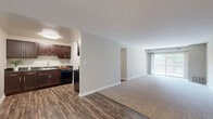 Located at 16W472 Honeysuckle Rose Ln in Willowbrook, IL, this single-floor, three-bedroom, one-bathroom residence offers a well-organized layout designed for comfortable everyday living. The open-concept kitchen and living room serve as the heart of the home, with the kitchen featuring rich dark wood cabinetry, dark granite-style countertops, a gas range, dishwasher, and a stainless steel sink — all set atop durable wood-style flooring. The spacious living room is carpeted and filled with natural light from a large sliding glass door that opens to a private balcony with outdoor views of lush greenery. Three bedrooms provide ample accommodation, each finished with neutral carpet, soft-toned walls, and windows that bring in natural light. The primary bedroom offers generous proportions and closet space. A dedicated closet features built-in hanging rods for storage convenience. The full bathroom includes a tub-shower combination with white tile surround, clean white fixtures, and wood-style flooring. A connecting hallway ties the rooms together efficiently. Neutral tones, clean finishes, and a practical floor plan make this a functional and inviting residence in a serene Willowbrook setting.