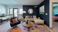 Located in Hartford, CT, this single-floor unit offers a well-designed layout that balances modern finishes with functional living spaces. The kitchen is outfitted with dark espresso cabinetry, a white subway tile backsplash, light stone countertops, and a full suite of stainless steel appliances, including a refrigerator, range, microwave, and dishwasher. Light wood-tone flooring flows seamlessly from the kitchen into the open living and dining areas, creating a cohesive and airy feel throughout.

The living room makes a strong visual statement with a deep navy accent wall, recessed lighting, and direct access to a private balcony through glass-paned doors. The balcony overlooks the Hartford cityscape, offering urban views. Windows on multiple sides bring in natural light, enhancing the open atmosphere of the space.

The bedroom features plush carpeting, two windows with city views, a bold teal accent wall, and a generously sized closet. The bathroom is clean and contemporary, finished with large-format tile flooring, a granite-topped vanity with white cabinetry, and a full soaking tub with shower combination set against crisp white surroundings.