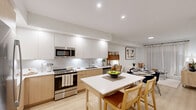 Located at 590 NW 159th St in Miami, FL, this well-appointed one-bedroom, one-bathroom unit offers a thoughtfully designed single-floor layout with a bright, contemporary aesthetic. The open-concept living and kitchen area forms the heart of the home, featuring light wood-finish cabinetry paired with crisp white upper cabinets, white quartz countertops, and a full suite of stainless steel appliances including a refrigerator, range, microwave, and dishwasher. A central kitchen island doubles as a casual dining space, seamlessly connecting to a dedicated dining area. Light hardwood-style flooring runs throughout the main living spaces, enhancing the airy, cohesive feel. The living room offers a relaxed, minimalist ambiance with clean white walls and sheer curtains that soften natural light. The bedroom is a calm retreat, complete with a ceiling fan, sheer window treatments, and ample space for a full furniture arrangement. A ceiling fan adds comfort and functionality. The full bathroom features large-format tile flooring and wall surround, a soaking tub with shower, a wood-framed vanity with white countertop, and a large wall mirror. Recessed lighting throughout the unit contributes to a clean, modern finish, making this Miami residence a comfortable and stylish living space.
