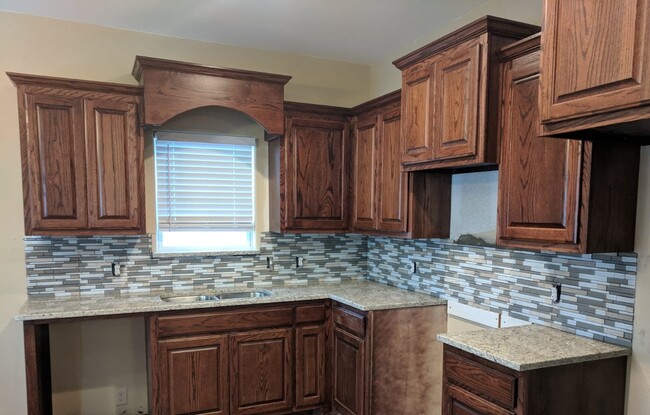 kitchen with granite countertops and nice backsplash - 415 N Grand Ave