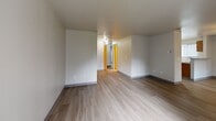 Located at 908 76th St E in Tacoma, Washington, this ground-floor unit offers a practical and well-organized single-level layout with two bedrooms and three bathrooms. The living room serves as the heart of the home, featuring light wood-style flooring, a classic fireplace with a simple mantel, and a large window with vertical blinds that fills the space with natural light and provides outdoor views. Adjacent to the living room, the kitchen is efficiently designed with warm wood cabinetry, gray laminate countertops, a double stainless steel sink, and white appliances including a refrigerator and electric range. A peninsula counter adds prep space and helps define the kitchen from the surrounding area. A pantry closet with built-in shelving provides ample storage. Both bedrooms are carpeted in a neutral gray tone, offering a comfortable and quiet feel. Each bedroom includes windows with vertical blinds and generous closet space, with the primary bedroom featuring a large sliding-door closet. The three bathrooms are clean and straightforward, with speckled gray countertops, full-width mirrors, and a tub-shower combination. A connecting hallway links the main living areas to the bedrooms and bathrooms, ensuring a smooth and logical flow throughout the unit.
