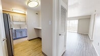 Located on Indian School Road NE in Albuquerque, New Mexico, this single-floor residence offers four bedrooms, two bathrooms, a living room, kitchen, entrance, and hallway. The layout is thoughtfully arranged, with a welcoming entrance that flows into the main living and kitchen areas via a connecting hallway.

The living room is a standout space, featuring light wood-look flooring, a ceiling fan, and a full wall of vertical-blind-covered sliding doors that flood the room with natural light and offer views of the surrounding Albuquerque cityscape. The kitchen is well-appointed with gray shaker-style cabinetry, white countertops, stainless steel appliances including a range and over-the-range microwave, a double basin sink, and matching wood-look flooring. A convenient built-in countertop ledge just off the kitchen serves as an ideal workspace or breakfast bar.

The bedrooms are carpeted for comfort, each equipped with ceiling fans and generous window coverage dressed with vertical blinds that invite natural light. The primary bedroom is notably spacious, with a louvered closet door adding a clean, classic touch.

The two bathrooms are finished with gray vanity cabinetry, quartz-style countertops, and wood-look flooring. One bathroom features a walk-in shower with glass doors, while the second includes a tub-shower combination with frosted sliding glass enclosure and white tile surround.