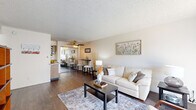 Located at 1522 E Southern Ave in Tempe, Arizona, this one-bedroom, one-bathroom unit offers a practical and well-organized single-floor layout. The living room serves as the heart of the home, featuring dark hardwood-style flooring, neutral-toned walls, and a large window dressed with sheer curtains that invite abundant natural light. A ceiling fan overhead adds comfort, while the open sightline flows seamlessly into the adjacent dining area, creating a connected and functional common space. The kitchen is positioned just off the living and dining areas, providing convenient access for everyday living. The bedroom is a comfortable retreat with plush carpeting, a large window that fills the room with natural light, and direct access to the hallway and bathroom. A dedicated closet provides organized storage. The full bathroom features a wood-toned vanity with a granite-style countertop, a full tub and shower combination, and dark hardwood-style flooring that ties in with the rest of the unit. Throughout the space, textured ceilings and clean white walls create a bright, cohesive aesthetic. A hallway connects all rooms efficiently, rounding out this compact yet thoughtfully designed Tempe residence.