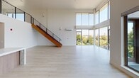 Located in the heart of Sacramento's Midtown neighborhood, this sophisticated two-story residence at 1431 Q St offers an exceptional blend of modern architecture and high-end finishes. The main living area commands immediate attention with its dramatic double-height ceilings and an expansive wall of floor-to-ceiling windows that flood the space with natural light and frame sweeping views of the surrounding treetops and city skyline. Light-toned hardwood flooring flows throughout both levels, complementing the clean, minimalist aesthetic.

A striking wood-and-steel staircase connects the two floors, with the upper level featuring a sleek metal railing that overlooks the grand living area below, along with a ceiling fan and additional windows capturing generous natural light. The gourmet kitchen is equipped with a professional-grade stainless steel range with gas burners and griddle, complemented by warm wood cabinetry, quartz countertops, and a marble-veined glass backsplash.

The bathrooms are finished to a spa-like standard, showcasing bold marble-style tile work, a glass-enclosed walk-in shower, a soaking tub, wood-toned vanities, and illuminated mirrors. A dedicated laundry room houses full-size side-by-side washer and dryer units with built-in shelving above, adding everyday convenience to this refined urban residence.