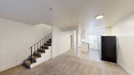 Located at 3376 Claremont Dr in Santa Rosa, CA, this efficiently designed single-floor unit offers a thoughtful layout that makes great use of its compact footprint. The combined kitchen and living area serves as the heart of the space, with the two zones flowing seamlessly into one another. The living area features neutral wall-to-wall carpeting, clean white walls, and a staircase with a sleek black metal railing that adds a modern architectural touch. A large sliding glass door fitted with vertical blinds allows natural light to fill the room. The kitchen is designed in a galley style, featuring white shaker cabinetry with matte black hardware, white quartz countertops, and light wood-look vinyl flooring. Stainless steel appliances — including a full-size refrigerator, dishwasher, and electric range — are included, and a window above the sink brings in additional natural light with views of the surrounding greenery. The entrance provides a welcoming transition into the main living space, and a dedicated closet offers practical storage. The bathroom completes the layout. Throughout the unit, flush-mount ceiling lighting and a bright, neutral palette create a clean, modern ambiance that is both functional and inviting.