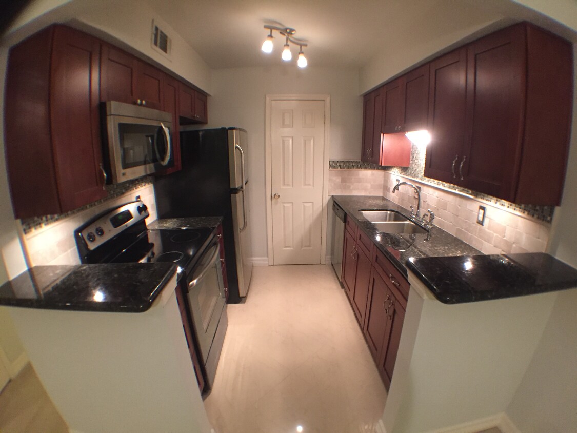 Updated kitchen with granite counter tops and marble tile flooring - 7555 Katy Freeway