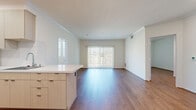 Located at 300 N Beaudry Ave in downtown Los Angeles, this 2-bedroom, 2-bathroom residence offers a well-designed single-floor layout with a clean, modern aesthetic throughout. Warm hardwood-style flooring flows seamlessly across the living areas and bedrooms, complemented by crisp white walls and crown molding that lend a polished finish.

The open living room is bright and inviting, featuring sliding glass doors with vertical blinds that lead to a private balcony, filling the space with natural light. The galley-style kitchen is thoughtfully appointed with light wood cabinetry, white quartz countertops, a subway tile backsplash, stainless steel appliances, and recessed lighting — a functional and attractive space for cooking and entertaining.

Both bedrooms are well-proportioned and filled with natural light through large windows dressed with vertical blinds. The primary bedroom offers a generous footprint, while the second bedroom provides a comfortable and versatile space. A dedicated closet adds practical storage.

The two bathrooms are finished with large-format beige tile flooring and striking marble-style tiled tub surrounds, paired with light wood vanities and white countertops for a serene, spa-like feel. Recessed lighting throughout adds a refined touch to the overall ambiance of this well-appointed Los Angeles residence.