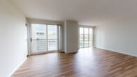 Located at 18 American Express Plaza in the heart of Providence, Rhode Island, this thoughtfully designed single-floor residence offers a clean, modern aesthetic throughout. Warm hardwood-style flooring flows seamlessly across every room, creating a cohesive and inviting atmosphere.

The expansive main living area is a standout feature, bathed in natural light through large sliding glass doors that open to a private balcony, offering urban views of the surrounding cityscape. A second living or dining area continues the open, airy feel, with additional windows drawing in plenty of daylight.

The kitchen is outfitted with crisp white cabinetry, stone-toned countertops, a stainless steel sink, and a bold dark subway tile backsplash that adds a contemporary contrast. A dishwasher is included for added convenience.

Bedrooms are generously proportioned with large windows and ample storage. One bedroom features a walk-in closet equipped with wire shelving and hanging rods, while bifold doors provide easy access. The bathrooms are well-appointed with full tub-and-shower combinations, framed mirrors, and wood-toned vanities, maintaining a consistent, clean design.

The layout, as revealed by the floorplan, is efficiently organized with well-defined living, sleeping, and service zones — making this a highly functional urban residence in a prime Providence location.