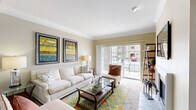 Located in O'Fallon, Missouri, this single-floor, 3-bedroom, 2-bathroom home offers a thoughtfully designed layout across a comfortable footprint. The living room serves as the heart of the home, featuring crown molding, a classic fireplace, and large sliding glass doors that invite abundant natural light and provide views of the outdoors. The adjacent dining area continues the warm, neutral color palette, with rich hardwood-style flooring, a tray ceiling with crown molding detail, and a pendant light fixture that anchors the space. The galley-style kitchen is efficiently arranged with ample light wood cabinetry, dark granite-style countertops, and black appliances, including a refrigerator, range, and dishwasher. A doorway from the kitchen provides convenient access to the in-unit laundry room. The spacious primary bedroom features plush carpeting, a large window with outdoor views, and generous room for furnishings. The additional bedrooms are similarly bright and carpeted, each with windows overlooking the surroundings. The bathrooms include warm wood cabinetry and hardwood-style flooring. A dedicated closet and laundry room round out this functional and inviting home.