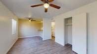 This single-floor, 3-bedroom, 2-bathroom home features a practical and efficient layout designed to maximize every square foot. The combined kitchen and living area serves as the heart of the home, where durable wood-look flooring flows throughout the open space. The kitchen is equipped with white cabinetry, a gas range, a refrigerator, and a peninsula countertop with a double-basin sink — ideal for both meal preparation and casual dining. The living room is bright and welcoming, featuring a ceiling fan with a light fixture and a window that allows natural light to filter in. Each bedroom offers its own ceiling fan, built-in closet with shelving, and neutral-toned walls. The bedrooms transition between wood-look flooring and plush carpet, adding a comfortable, cozy feel to the private spaces. The bathrooms are clean and functional, with white cabinetry, a single-basin vanity with a warm-toned countertop, and a tiled shower-tub combination. A hallway and dedicated closet provide additional storage and connectivity between rooms. Ceiling fans are present throughout the home, ensuring consistent airflow and comfort. The overall aesthetic is clean, neutral, and move-in ready.