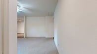Located at 1201 Wilcrest Drive in Houston, TX, this single-story home offers five bedrooms and two full bathrooms across a practical and efficiently organized floor plan. The bedrooms are carpeted throughout and feature neutral, light-toned walls that create a clean and airy atmosphere. Ceiling fans are installed in the bedrooms, providing year-round comfort. Several bedrooms include windows fitted with horizontal blinds, allowing natural light to filter in while maintaining privacy. The primary bedroom is notably spacious and includes direct access to both a walk-in closet with dual hanging rods and an en-suite bathroom, offering added convenience and storage. A second walk-in closet is also available elsewhere in the home. Both bathrooms are finished with wood-look vinyl flooring, white tiled tub-shower combinations, and granite-topped vanities, delivering a clean and updated aesthetic. The kitchen is outfitted with granite countertops, modern wood-toned cabinetry, a stainless steel sink, and black appliances including a dishwasher and refrigerator, all set over durable wood-look flooring. The overall design emphasizes practicality and comfort, making this a well-suited home for larger households.