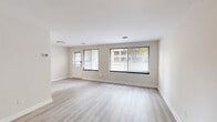 Located at 2000 N Adams St in Arlington, VA, this 3-bedroom, 1-bathroom residence offers a thoughtfully arranged single-level layout. The living room is a standout feature, bathed in natural light through multiple large windows dressed with horizontal blinds, highlighting the light-toned hardwood-style flooring and neutral walls that create a clean, airy atmosphere. The kitchen is well-appointed with white shaker-style cabinetry, granite-look countertops, and a full suite of stainless steel appliances including a gas range, over-the-range microwave, and refrigerator, all complemented by the same light flooring that flows throughout the main living areas. The primary bedroom is generously sized and features plush carpeting, a ceiling fan with light fixture, a window with outdoor views, and a closet. The additional bedrooms also offer carpeted flooring and ceiling fans, with one featuring a walk-in closet equipped with built-in shelving and hanging rods. The bathroom includes a tiled tub and shower surround in a crisp white finish. Throughout the residence, a consistent neutral color palette and clean finishes contribute to a bright, move-in-ready ambiance.