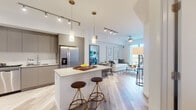 Located at 475 Hialeah Dr in Hialeah, FL, this contemporary single-floor residence offers a thoughtfully designed open-concept layout with clean lines and modern finishes throughout. Light wood-look flooring flows seamlessly across the living, dining, and kitchen areas, creating a cohesive and airy atmosphere.

The living room is bright and inviting, anchored by a ceiling fan, large-scale wall art, and floor-to-ceiling sliding glass doors that open onto a private balcony, allowing abundant natural light and outdoor views.

The kitchen is a standout feature, equipped with flat-front taupe cabinetry, quartz countertops, stainless steel appliances including a refrigerator, range, microwave, and dishwasher, as well as a central island with bar seating and pendant lighting overhead. A stacked in-unit washer and dryer is conveniently tucked nearby.

The primary bedroom is a serene retreat with a ceiling fan, natural light from a window, and direct access to a walk-in closet and an en-suite bathroom. A second well-proportioned bedroom provides additional flexibility. The bathroom features large-format tile, a soaking tub with shower, and a clean floating vanity with quartz countertop. The overall design balances functionality with a refined, contemporary aesthetic.