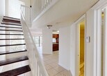 Located at 12325 SW 151st St in Miami, FL, this two-story home offers a thoughtfully designed layout across two levels. The main floor welcomes you with light-toned ceramic tile flooring that flows throughout the open living and dining areas. Large windows and a sliding glass door invite abundant natural light and provide views of the surrounding greenery. A ceiling fan in the living area adds a practical touch to the airy, open feel of the space.

The kitchen is outfitted with rich dark wood cabinetry, granite countertops, black appliances including a refrigerator and electric range, and tile flooring, offering both functionality and visual contrast. A convenient half bathroom with a granite-topped vanity is also located on the main level.

A staircase with dark wood treads and a white balustrade leads to the upper floor, which features a landing overlooking the main living area below — adding a sense of vertical openness to the home. Upstairs, carpeted bedrooms provide a softer, more comfortable feel, with windows framing lush outdoor views. The upper-level bathroom includes a granite vanity with rich wood cabinetry, a tub-shower combination with tile surround, and stylish brushed nickel fixtures. Throughout, the home maintains a clean, neutral palette that enhances its bright and welcoming ambiance.