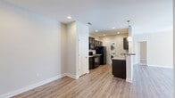 Located at 1061 Spring Creek Dr in Forest, VA, this two-story home offers a thoughtfully designed layout spread across two comfortable floors. The main level welcomes you into a bright, open living room featuring light hardwood-style flooring, a ceiling fan, and multiple windows that flood the space with natural light and views of the surrounding landscape. A front entry door with transom window adds an inviting touch. The kitchen and dining area flow seamlessly together, showcasing rich dark espresso cabinetry, granite countertops, stainless steel appliances including a range and built-in microwave, and recessed lighting — a functional yet stylish space for cooking and entertaining. The main floor also includes a dedicated laundry area. Upstairs, three bedrooms provide comfortable retreats, each with plush carpet flooring, ceiling fans, and windows offering natural light. The spacious primary bedroom includes a walk-in closet and private access to its own bathroom. All three bathrooms are finished with dark vanity cabinetry, white countertops, and neutral tile flooring, maintaining a consistent, clean aesthetic throughout. Ample closet storage — with six closets across the home — ensures practical living. The home's neutral color palette, modern finishes, and well-organized floor plan make it a versatile and move-in-ready residence.