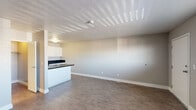 This efficiently designed single-floor studio offers a thoughtful layout that maximizes every square foot. The combined kitchen and living area forms the heart of the space, featuring warm wood-look vinyl plank flooring, neutral gray walls, and a textured ceiling that adds subtle character. A wall-mounted HVAC unit and a window with horizontal blinds allow for natural light and climate control, keeping the living area bright and comfortable.

The kitchen is well-appointed with crisp white cabinetry providing ample storage, dark speckled countertops that extend across a peninsula cooktop, a stainless steel sink, and a built-in dishwasher. The peninsula separates the kitchen from the living area, creating a functional open-concept feel.

The bathroom is clean and straightforward, equipped with a full-size tub and shower combo, chrome fixtures, and towel bars. The closet offers dedicated storage to keep the living space organized and uncluttered.

Throughout the unit, consistent flooring and a neutral color palette create a cohesive, move-in-ready environment. The overall ambiance is practical and tidy, making it a functional space well-suited for efficient, everyday living.