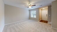 Located at 10 White Dr in Beaufort, South Carolina, this two-story home offers a functional and well-designed layout across two floors. The kitchen is a standout feature, showcasing bold dark cabinetry contrasted by light marble-style countertops, stainless steel appliances including a refrigerator, range, and dishwasher, and durable wood-look flooring. Natural light filters in through a window above the sink, while a sliding glass door provides additional brightness and outdoor access.

The living areas transition seamlessly between floors via a carpeted staircase. Multiple bedrooms are found throughout the home, each featuring plush carpeting, ceiling fans with light fixtures, and windows with blinds that allow for natural light. Closets with bifold doors provide ample storage in the bedrooms.

The bathrooms are thoughtfully appointed. The full bathroom upstairs includes a vanity with marble-style countertops, dark cabinetry, a large mirror, and a tub-shower combination with wood-look flooring. A convenient half bath on the lower level features a pedestal sink and a medicine cabinet mirror, offering a clean and compact design. Neutral warm tones throughout the home create a cohesive, welcoming atmosphere well-suited to the Lowcountry setting.