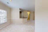 Located at Beacon Square in Gaithersburg, MD, this well-appointed 2-bedroom, 2-bathroom unit offers a thoughtfully designed single-level layout with generous living space throughout. The open-concept living and kitchen area serves as the heart of the home, anchored by a classic fireplace with a white-painted mantle and crown molding trim. Large windows flood the living room with natural light and frame serene, tree-lined views, with direct access to a private balcony overlooking lush greenery. The kitchen is outfitted with rich, dark wood cabinetry, granite countertops, hardwood-style flooring, and a full suite of stainless steel appliances including a gas range, built-in microwave, and dishwasher, all centered around a convenient peninsula. The spacious primary bedroom offers a generous walk-in closet with built-in shelving. Both bathrooms feature wood-toned vanities with granite countertops and hardwood-style flooring, with one bath showcasing a full soaking tub and tiled surround. An additional den provides flexible space for a home office or guest room. Six closets offer exceptional storage throughout. Neutral carpet and warm beige tones create a cohesive, inviting ambiance across the entire residence.