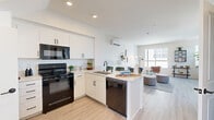 Located at 2915 E St in San Diego, CA, this modern multi-story residence spans five levels and offers three bedrooms and one bathroom with a clean, contemporary design aesthetic. Light wood-look flooring runs throughout, complemented by crisp white walls and recessed lighting that create a bright, airy atmosphere.

The combined kitchen and living area serves as the heart of the home, featuring white shaker cabinetry, light stone countertops, a peninsula with an undermount sink, and black appliances including a range, built-in microwave, dishwasher, and refrigerator. A wall-mounted mini-split unit provides climate control. The open-plan layout flows seamlessly into a generously sized living area, which is bathed in natural light from multiple large windows offering views of the surrounding San Diego cityscape.

The three bedrooms are well-proportioned, each featuring large windows that welcome abundant natural light and urban views. The primary bedroom provides a comfortable, private retreat with ample space. The shared full bathroom is neatly appointed with a tub-shower combo, a wide vanity with a rectangular undermount sink, dark hardware accents, and open wall shelving. Multiple staircases connect the five levels, with hallways providing smooth circulation throughout this thoughtfully laid-out urban residence.