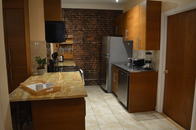 Contemporary galley kitchen w/exposed brick - 844 Grand Ave
