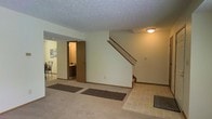 Located at 3581 Esquire Dr in Canal Winchester, Ohio, this two-story home offers a functional and comfortable layout designed for everyday living. The entry level features a generously sized open area with a mix of carpet and tile flooring, providing a welcoming transition into the home. A staircase with a wooden railing rises prominently from the main level, connecting the two floors with ease. The textured ceiling adds classic architectural character throughout, while flush-mount lighting provides practical illumination. Adjacent to the main living area, a glimpse into the dining space reveals room for a full dining set, with an open doorway leading to what appears to be a bathroom or utility room, offering added convenience on the main floor. The neutral color palette of soft whites and warm beiges throughout creates a clean, versatile canvas ready for personalization. The layout flows naturally between spaces, making the home feel cohesive and well-organized. With its multi-level design, tiled entryway, and carpeted living areas, this Canal Winchester property presents a solid, move-in-ready home in a residential neighborhood setting.