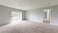 Located at 3408 Lancaster Court in Tampa, FL, this single-floor home offers three bedrooms and three bathrooms across a well-organized layout. The living area features plush carpeting and a textured ceiling, with a sliding glass door opening to a private balcony that overlooks green outdoor surroundings, bringing in natural light and a refreshing outdoor connection. The transition from the carpeted living space to wood-look tile flooring marks the entry and dining area, creating a clean visual distinction between zones. The kitchen is outfitted with white cabinetry, white countertops, a full suite of white appliances including an electric range, and ample upper and lower cabinet storage. The three bedrooms are finished with soft carpeting and feature windows that allow natural light to filter in, while neutral gray walls provide a versatile backdrop. The primary bedroom offers a generous footprint suitable for a full furniture arrangement. All three bathrooms include vanities with light stone-tone countertops, large mirrors, and wood-look tile flooring. Two of the bathrooms feature a combined tub and shower setup. A dedicated closet and hallway round out the functional layout, making this a practical and well-appointed home in Tampa.