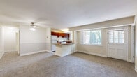 Located at 4239 58th Ave in Bladensburg, MD, this single-floor, three-bedroom, one-bathroom home offers a well-organized and functional layout. The open-concept living room and kitchen area serves as the heart of the home, featuring neutral-toned carpet, a ceiling fan, and a peninsula breakfast bar that connects the two spaces seamlessly. The kitchen is equipped with rich, warm-toned cabinetry, granite-style countertops, a gas range, and a window above the sink that brings in natural light. Built-in open shelving adds a practical storage element to the kitchen. The living room is generously sized, with large windows offering outdoor views of surrounding greenery, and a wall sconce adding a warm ambiance. Each of the three bedrooms is carpeted and features neutral wall tones, with windows that invite natural light and outdoor views. The primary bedroom is notably spacious and includes its own window with garden views. The additional bedrooms each include closet storage. The bathroom is clean and well-appointed, featuring tile flooring, a full tub-shower combination with white subway tile surround, and a wood-toned vanity. A connecting hallway provides easy access to all rooms, and two closets offer additional storage throughout the home.