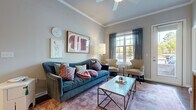 The Allister presents a thoughtfully designed two-bedroom, two-bathroom residence in Columbia, SC, offering comfortable single-floor living with a cohesive and stylish interior throughout. The open-concept living room features crown molding, a ceiling fan, and large windows that invite abundant natural light, creating a warm and inviting atmosphere. The kitchen is equipped with dark espresso cabinetry, stainless steel appliances, a center island with bar seating, pendant lighting, and rich hardwood flooring that extends seamlessly into the adjacent dining area — ideal for both everyday meals and entertaining. The dining space accommodates a full table and benefits from the same rich flooring and crown molding detail. The primary bedroom is generously proportioned, featuring plush carpeting, vaulted ceilings, and a walk-in closet, offering a comfortable private retreat. The second bedroom is equally well-sized with soft carpeting and ample wall space. Both bathrooms are finished with granite countertops, dark wood vanities, and tile flooring, with one featuring a tub/shower combination. Throughout the residence, consistent architectural detailing, neutral tones, and quality finishes contribute to a refined and livable aesthetic.