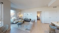 Located at 1919 Pacific Hwy in San Diego, this thoughtfully designed residence offers a bright, contemporary aesthetic throughout its single-floor layout. The open-concept living area is bathed in natural light from expansive corner windows that frame sweeping views of the harbor, marina, and palm-lined waterfront, creating a seamless indoor-outdoor connection. Light hardwood flooring extends throughout, complementing the neutral, warm color palette.

The kitchen is outfitted with flat-front cabinetry in warm wood tones, stainless steel appliances including a gas range and built-in microwave, and a generous peninsula with quartz countertops and bar seating—ideal for casual dining and entertaining.

The bedrooms are serene and well-appointed, each featuring windows with waterfront or outdoor views. Sliding glass-panel closets and roller shades add a clean, modern touch. The primary bedroom benefits from direct views of the marina and palm trees.

The bathrooms are finished with large-format tile and clean, minimalist fixtures. One features a soaking tub with tiled surround and built-in open shelving, while another offers a frameless glass walk-in shower. The overall ambiance throughout is calm, polished, and distinctly coastal.