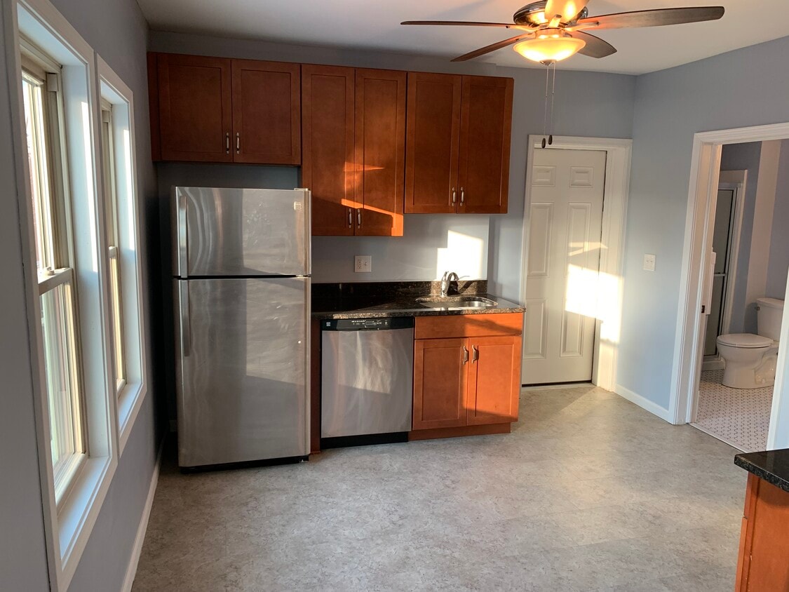 Kitchen - Appliances, ceiling fan, and apartment entrance - 3817 Lorain Avenue