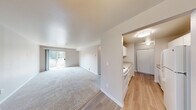 Located at 1800 S 330th St in Federal Way, Washington, this single-floor, 2-bedroom, 1-bathroom residence offers a practical and comfortable layout. The living room is carpeted and flows into a dining area highlighted by hardwood flooring and a chandelier overhead, creating a warm transition between spaces. A sliding glass door in the living area provides direct access to an outdoor balcony, filling the room with natural light and views of surrounding greenery.

Both bedrooms are carpeted and feature neutral-toned walls, built-in sliding closets, and baseboard heating units. The spacious primary bedroom includes a window with natural light, while the second bedroom also benefits from a dedicated window and ample closet storage. Each room maintains a clean, understated aesthetic with white trim and soft wall tones throughout.

The bathroom is straightforward and functional, equipped with a full-size tub and shower combination, wood-look flooring, and a vanity with countertop. Baseboard heating is present throughout the unit, ensuring consistent warmth across all rooms. The overall layout is efficiently designed, making good use of the available floor space to provide a livable and well-organized home in Federal Way.
