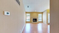 Located at 5121 Garfield Ave in Sacramento, CA, this single-floor, 3-bedroom, 3-bathroom home offers a well-designed layout with consistent warm-toned finishes throughout. Hardwood flooring flows seamlessly across all living spaces, complementing the neutral beige walls and white trim that give the home a clean, cohesive aesthetic.

The open living room serves as the heart of the home, anchored by a tile-surround fireplace with a raised hearth and flanked by multiple windows that invite abundant natural light. An elegant chandelier marks the adjacent dining area, which connects directly to the kitchen. The kitchen features white cabinetry, granite countertops, a peninsula breakfast bar, black appliances including a range and refrigerator, and a skylight overhead that bathes the space in natural light.

Each of the three bedrooms continues the hardwood flooring theme. The primary bedroom includes a sliding glass door leading to a private balcony with tree-lined views, while additional bedrooms offer generous windows and mirrored closet doors. Two closets provide practical storage throughout the unit.

The three bathrooms are appointed with sliding glass shower enclosures and hardwood-style flooring, maintaining design consistency. This well-maintained home presents a comfortable and functional living environment in Sacramento's Arden-Arcade area.