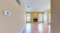 Located at 5121 Garfield Ave in Sacramento, CA, this single-floor, 3-bedroom, 3-bathroom home offers a well-designed layout with consistent warm-toned finishes throughout. Hardwood flooring flows seamlessly across all living spaces, complementing the neutral beige walls and white trim that give the home a clean, cohesive aesthetic.

The open living room serves as the heart of the home, anchored by a tile-surround fireplace with a raised hearth and flanked by multiple windows that invite abundant natural light. An elegant chandelier marks the adjacent dining area, which connects directly to the kitchen. The kitchen features white cabinetry, granite countertops, a peninsula breakfast bar, black appliances including a range and refrigerator, and a skylight overhead that bathes the space in natural light.

Each of the three bedrooms continues the hardwood flooring theme. The primary bedroom includes a sliding glass door leading to a private balcony with tree-lined views, while additional bedrooms offer generous windows and mirrored closet doors. Two closets provide practical storage throughout the unit.

The three bathrooms are appointed with sliding glass shower enclosures and hardwood-style flooring, maintaining design consistency. This well-maintained home presents a comfortable and functional living environment in Sacramento's Arden-Arcade area.