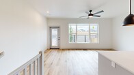 Located in Edmond, Oklahoma, this contemporary three-story home offers three bedrooms, three bathrooms, and a thoughtfully designed layout spread across three well-proportioned floors. The ground level features an attached garage with a modern panel door and direct interior access, along with additional flexible space finished with concrete floors. A clean, bright entrance welcomes you in, with light wood-tone flooring and carpeted stairs leading to the main living areas above. The main floor serves as the heart of the home, showcasing an open living area filled with natural light from large picture windows and a ceiling fan overhead. A sliding glass door provides access to an outdoor balcony area. The kitchen is elegantly appointed with white shaker-style cabinetry, quartz countertops, a herringbone tile backsplash, stainless steel appliances, and matte black hardware throughout. The upper floor houses the bedrooms, each with plush carpet and dedicated closets featuring built-in shelving. The primary bedroom includes a walk-in closet. Bathrooms are finished with dual-sink vanities, wood-look flooring, and glass-enclosed walk-in showers with tiled surrounds. Outside, a fenced backyard with young trees and a wooden gate offers a private outdoor retreat.
