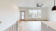 Located in Edmond, Oklahoma, this contemporary three-story home offers three bedrooms, three bathrooms, and a thoughtfully designed layout spread across three well-proportioned floors. The ground level features an attached garage with a modern panel door and direct interior access, along with additional flexible space finished with concrete floors. A clean, bright entrance welcomes you in, with light wood-tone flooring and carpeted stairs leading to the main living areas above. The main floor serves as the heart of the home, showcasing an open living area filled with natural light from large picture windows and a ceiling fan overhead. A sliding glass door provides access to an outdoor balcony area. The kitchen is elegantly appointed with white shaker-style cabinetry, quartz countertops, a herringbone tile backsplash, stainless steel appliances, and matte black hardware throughout. The upper floor houses the bedrooms, each with plush carpet and dedicated closets featuring built-in shelving. The primary bedroom includes a walk-in closet. Bathrooms are finished with dual-sink vanities, wood-look flooring, and glass-enclosed walk-in showers with tiled surrounds. Outside, a fenced backyard with young trees and a wooden gate offers a private outdoor retreat.