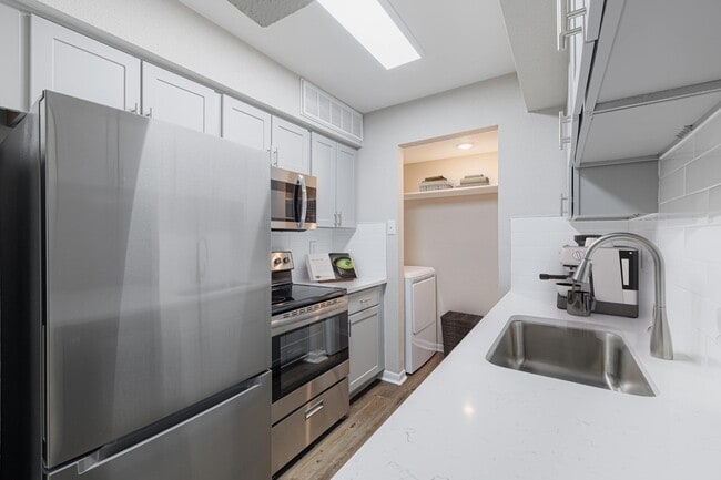 Kitchen with quartz countertops and stainless steel appliances - Oakgate at Pecan Grove