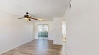Located at 400 SW Gordon St in Burleson, TX, this two-bedroom, one-bathroom unit offers a practical and comfortable single-floor layout. Wood-look laminate flooring runs consistently throughout the home, providing a clean and cohesive aesthetic. The living room is a bright, open space highlighted by a ceiling fan with light fixture and a sliding glass door that lets in natural light and offers views of the surrounding greenery. The kitchen is efficiently designed with light-toned laminate countertops, white cabinetry, a stainless steel sink, and a dishwasher, along with a window fitted with blinds that brightens the workspace. The two bedrooms feature the same wood-look flooring, textured ceilings, and neutral white walls, creating a simple and versatile canvas. The primary bedroom benefits from a window with natural light and direct access to the hallway, which also connects to a stacked washer and dryer unit. A dedicated closet provides additional storage with built-in shelving and hanging rods. The shared bathroom is outfitted with a tub-shower combination, grab bars, a vanity with countertop storage, and an overhead cabinet. Textured ceilings appear throughout the unit, adding a consistent design detail across all rooms.