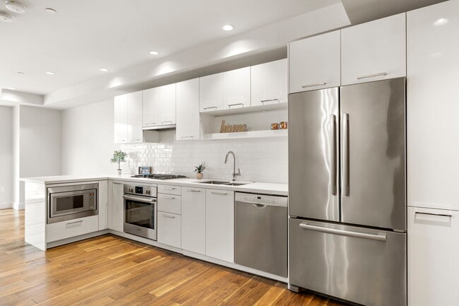 White cabinetry, quartz counters, and subway tile backplash - 4422 N 75th St