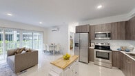 Located at 25850 SW 140th Ct in Homestead, FL, this well-appointed 2-bedroom, 2-bathroom unit offers a thoughtfully designed single-floor layout finished with large-format porcelain tile throughout. The kitchen is a standout feature, showcasing floor-to-ceiling wood-grain cabinetry, white quartz countertops, stainless steel appliances including a French door refrigerator and range, and a convenient movable island with a butcher block top. The open living and dining area is bright and welcoming, with recessed lighting, a wall-mounted mini-split system, and expansive sliding glass doors that lead to a private balcony overlooking lush greenery. The primary bedroom is a comfortable retreat with a wall-mounted mini-split unit and clean, minimalist finishes. The second bedroom also features direct outdoor access, natural light, and its own mini-split system. Both bathrooms are elegantly finished with marble-patterned wall tiles in the walk-in showers, floating wood-toned vanities, and modern chrome fixtures. Utility rooms provide additional storage and functional space. The private balcony offers tranquil views of landscaped grounds, completing this clean and modern residence.