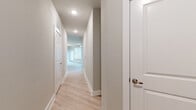 This single-floor residence offers a thoughtfully designed layout that balances open communal spaces with private retreats. The floor plan, as illustrated in the 3D model, reveals a well-organized arrangement of rooms connected by a long, light-filled hallway finished with light hardwood-style flooring and clean white trim, lending the space a bright, cohesive feel throughout.

The kitchen serves as the central hub of the home, anchored by a generously sized island featuring a granite countertop and an integrated sink. White cabinetry lines the walls, complemented by stainless steel appliances including a refrigerator, range, and microwave. Pendant lighting hangs above the island, adding warmth, while multiple windows fitted with horizontal blinds allow abundant natural light to flow into the adjacent living area.

The bedrooms are carpeted for comfort, each equipped with a ceiling fan and windows that bring in natural light and outdoor views. One room features light hardwood-style flooring, providing a versatile space suitable for varied uses.

The bathrooms maintain a consistent design language, featuring subway-tiled tub-and-shower combinations, granite-topped vanities with gray cabinetry, and light hardwood-style flooring, creating a clean, modern aesthetic throughout.