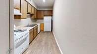 Located at 430 E Blackstock Rd in Spartanburg, SC, this single-floor unit offers a practical and well-organized layout suited for comfortable everyday living. The kitchen is equipped with warm oak-toned wood cabinetry both above and below the counters, a double stainless steel sink, a gas range with overhead ventilation, and a full suite of white appliances including a refrigerator. Light wood-look flooring runs through the kitchen and into the adjacent living and dining area, creating a cohesive and easy-to-maintain foundation throughout the main living spaces. The living area is open and airy, benefiting from a window that invites natural light into the room. Bedrooms feature plush wall-to-wall carpeting in neutral tones and are equipped with closets, including a bifold-door closet with a hanging rod for organized storage. The bathroom includes a full-size soaking tub and shower combination with chrome fixtures and a grab bar, set against clean white surroundings. Textured ceilings are present throughout the unit, and neutral wall tones provide a versatile backdrop. Overall, the space presents a clean, straightforward design that is functional and ready to personalize.