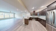 Located at 4805 W Genesee St in Syracuse, NY, this well-appointed 2-bedroom, 2-bathroom unit offers a thoughtfully designed single-floor layout with modern finishes throughout. Light wood-style flooring flows seamlessly across the living spaces, creating a clean and cohesive aesthetic.

The open-concept kitchen and living area serves as the heart of the home. The kitchen is outfitted with rich dark espresso cabinetry, marble-look granite countertops, a herringbone tile backsplash, a large center island with an undermount sink, and a full suite of stainless steel appliances including a refrigerator, range, microwave, and dishwasher. Recessed lighting illuminates the space effectively.

The spacious living room features large windows that invite natural light and a multi-blade ceiling fan, lending the room an airy feel. The generously sized primary bedroom connects to a private en-suite bathroom finished with marble-look tile flooring, a dark wood vanity with granite countertops, a tall storage tower, and a glass-enclosed shower. The second bedroom includes a double sliding-door closet and easy access to the second full bathroom, which also features marble-look tile and a granite vanity. A dedicated in-unit laundry room houses a full-size washer and dryer alongside additional cabinetry and countertop space.