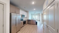 Located at 700 SE Veranda Place in Port Saint Lucie, Florida, this thoughtfully designed one-bedroom, one-bathroom residence offers a clean, modern aesthetic throughout its single-floor layout. Light-toned luxury vinyl plank flooring flows seamlessly through every room, complementing the bright white walls and creating a cohesive, contemporary feel.

The kitchen is a standout feature, showcasing a full suite of stainless steel appliances — including a side-by-side refrigerator, electric range, over-the-range microwave, and dishwasher. White shaker-style upper cabinets are paired with warm wood-toned lower cabinets, topped with granite countertops and accented by a classic white subway tile backsplash.

The entry area provides a welcoming transition into the home, with raised-panel doors, recessed lighting, and a double-door closet for convenient storage. The bedroom is generously proportioned, bathed in natural light through two windows with outdoor greenery views, and equipped with a ceiling fan. Direct access leads to the full bathroom, which features a soaking tub and shower combination adorned with large-format marble-style tile surround. A dedicated walk-in closet with multi-tier wire shelving offers ample organization space, completing this efficiently designed and move-in-ready residence.