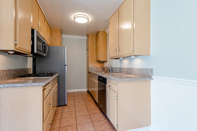 Kitchen with fridge, cooktop, microwave, dishwasher, and wall oven - Don Tomaso Apartments