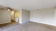 Located at 221 E Main St in Carmel, Indiana, this one-bedroom, two-bathroom residence offers a practical and well-designed single-floor layout. The living room is generously sized, featuring plush carpet, a ceiling fan, and large sliding glass doors that open to a private balcony, allowing abundant natural light and outdoor views. The transition between the carpeted living area and the hard-surface flooring leading into the kitchen is a notable design detail. The kitchen is fully equipped with stainless steel appliances — including a refrigerator, range, microwave, and dishwasher — complemented by white shaker cabinetry, granite countertops, a subway tile backsplash, and light wood-style flooring. The spacious primary bedroom includes a ceiling fan, plush carpet, and access to a walk-in closet area alongside an in-unit stacked washer and dryer. A second bedroom offers a ceiling fan, a closet, and a natural light window. Both bathrooms are finished with granite-topped vanities and wood-style flooring; one includes a full tub-shower combo. Neutral tones throughout create a clean, cohesive aesthetic suited for comfortable everyday living.